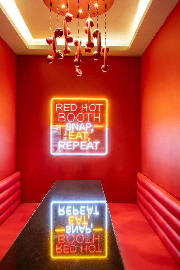 Red hot booth with neon sign: Snap, eat, repeat