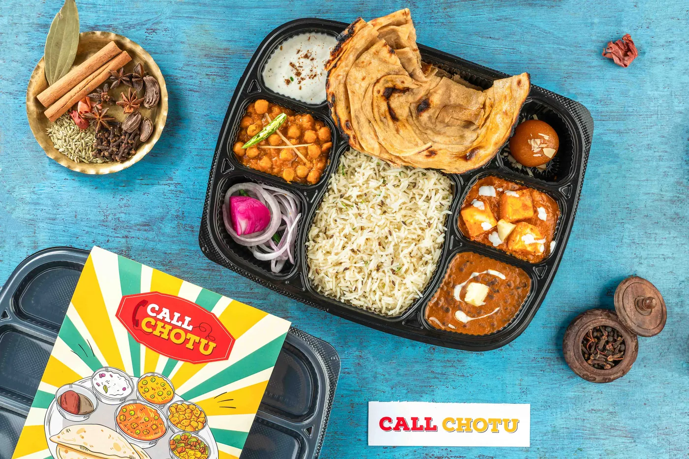 Packed paneer thali with lachha paratha, rice, chole, dal and paneer makhani