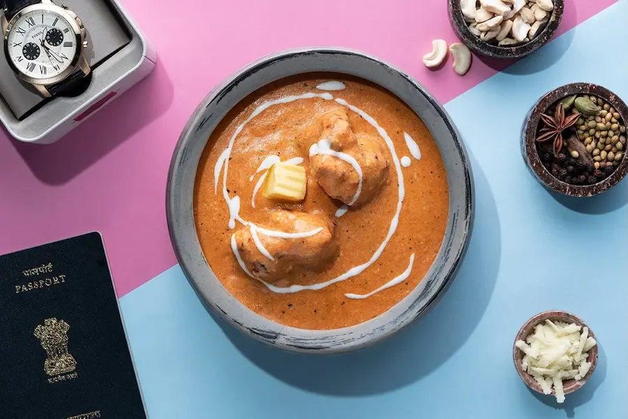 NRI wala butter chicken with a passport and watch